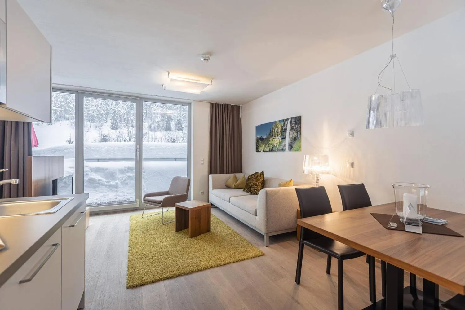 Schlafzimmer mit Doppelbett und Fensterblick auf schneebedeckte Berge