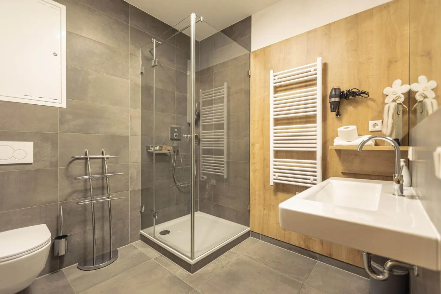 Modernes Badezimmer mit Dusche, weißem Waschbecken und Fliesen