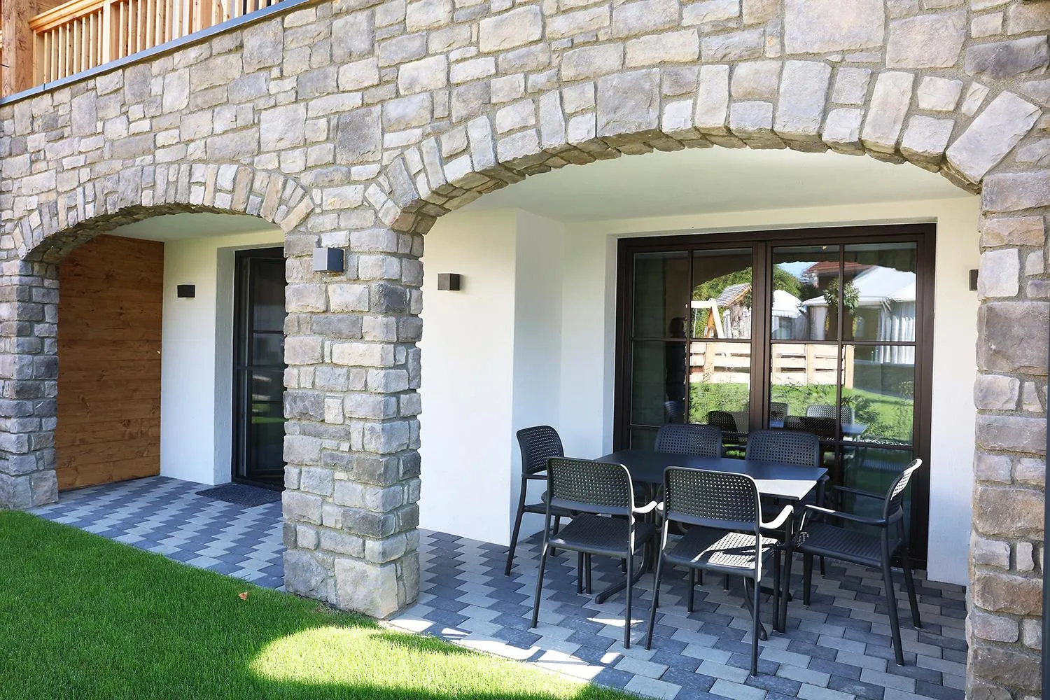 Terrasse mit Steinbogenarkaden und moderner Außenmöblierung