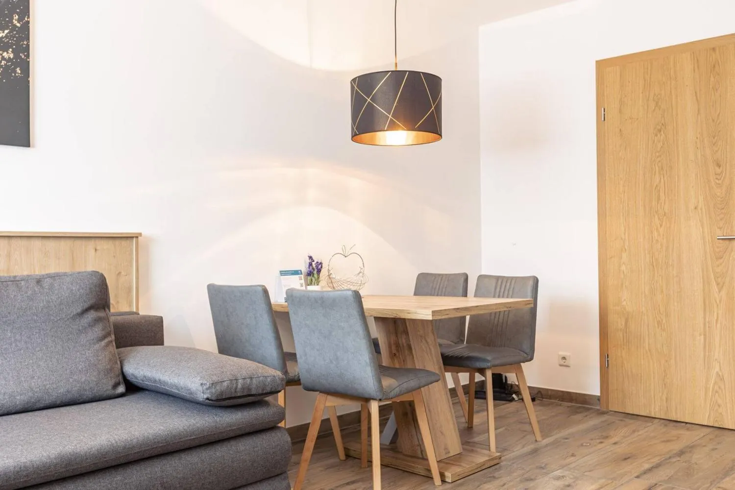 Appartement mit grauem Sofa und Holzmöbeln minimalistisch