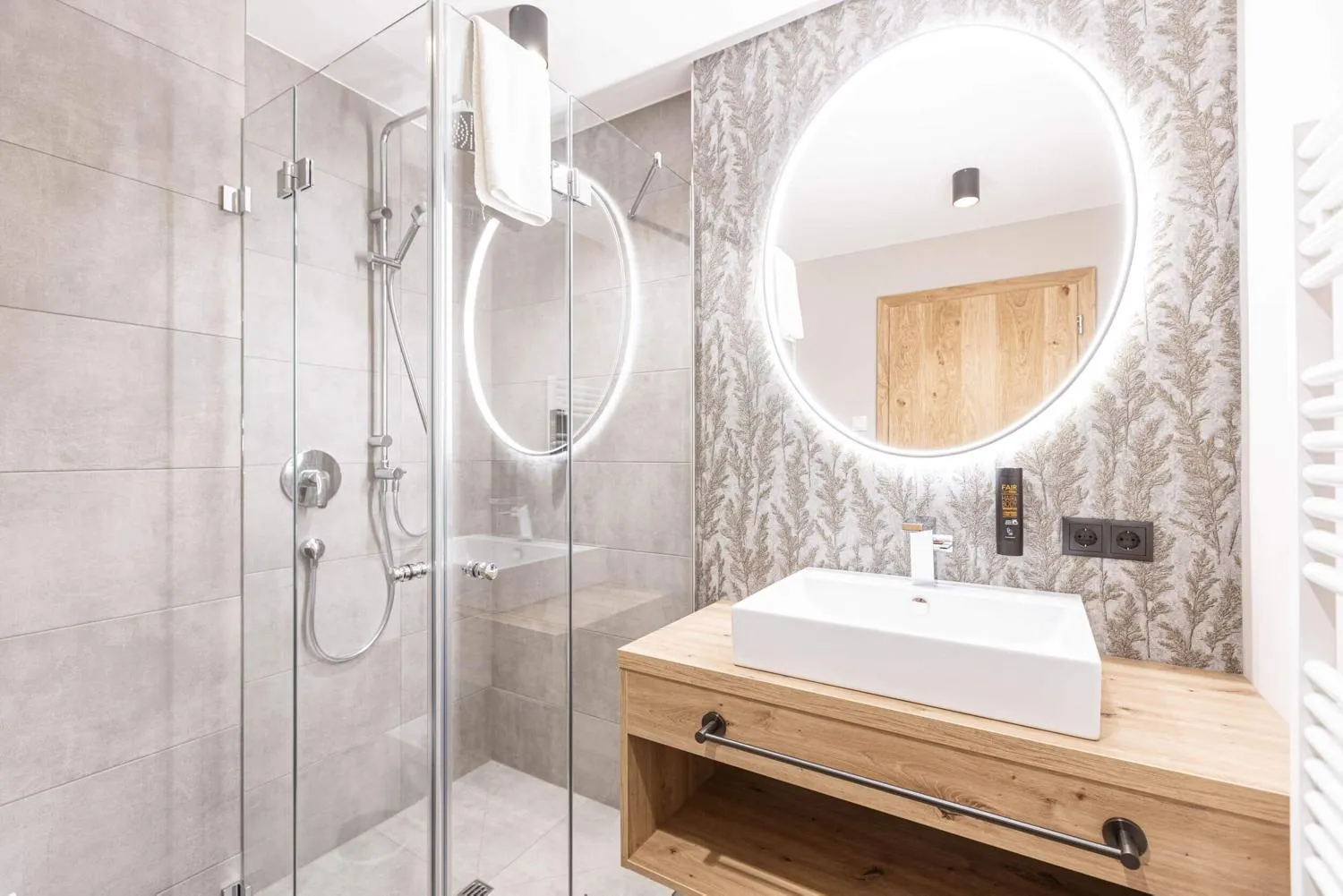 Luxus-Badezimmer mit rundem LED-Spiegel und moderner Ausstattung