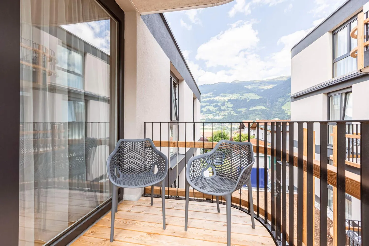 Balkon mit modernen Stühlen und Panoramablick auf das Zillertal