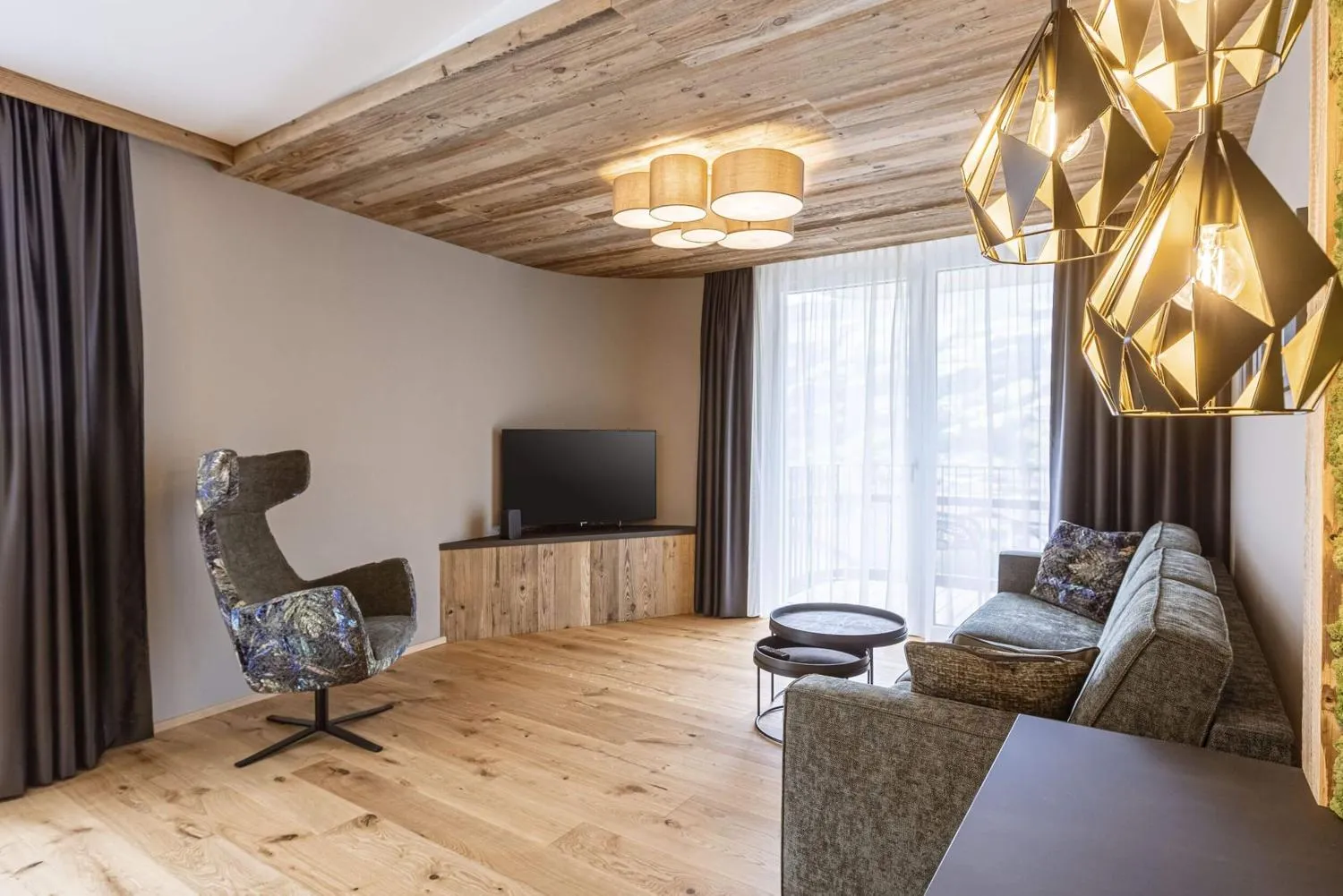 Geräumiger Wohnraum mit Holzdecke, Sofa und modernen Pendelleuchten