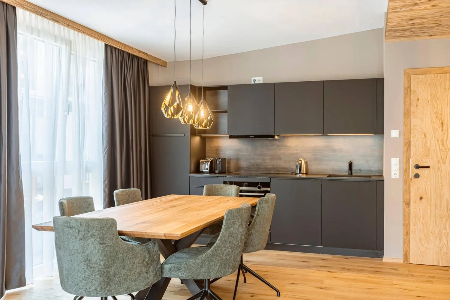 Offene Küche mit Esstisch, Holz und modernen Pendelleuchten