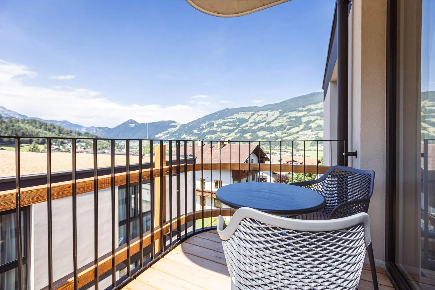 Großzügiger Balkon mit Lounge-Sesseln und Bergpanorama
