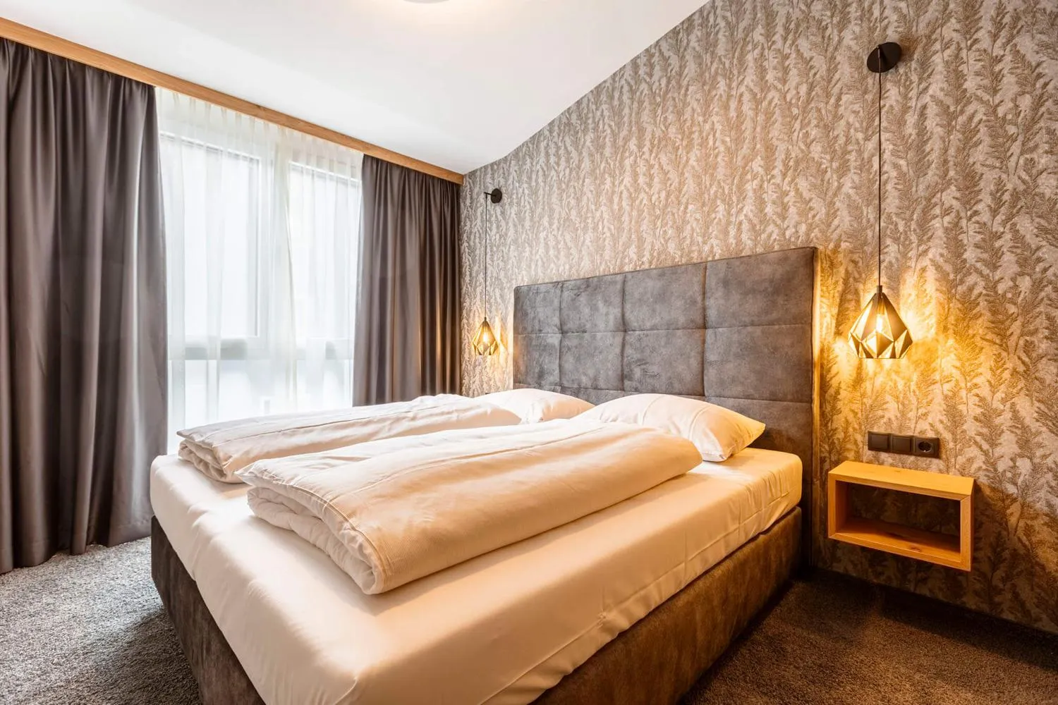 Modernes Schlafzimmer mit Doppelbett, grauem Kopfteil und Tapete