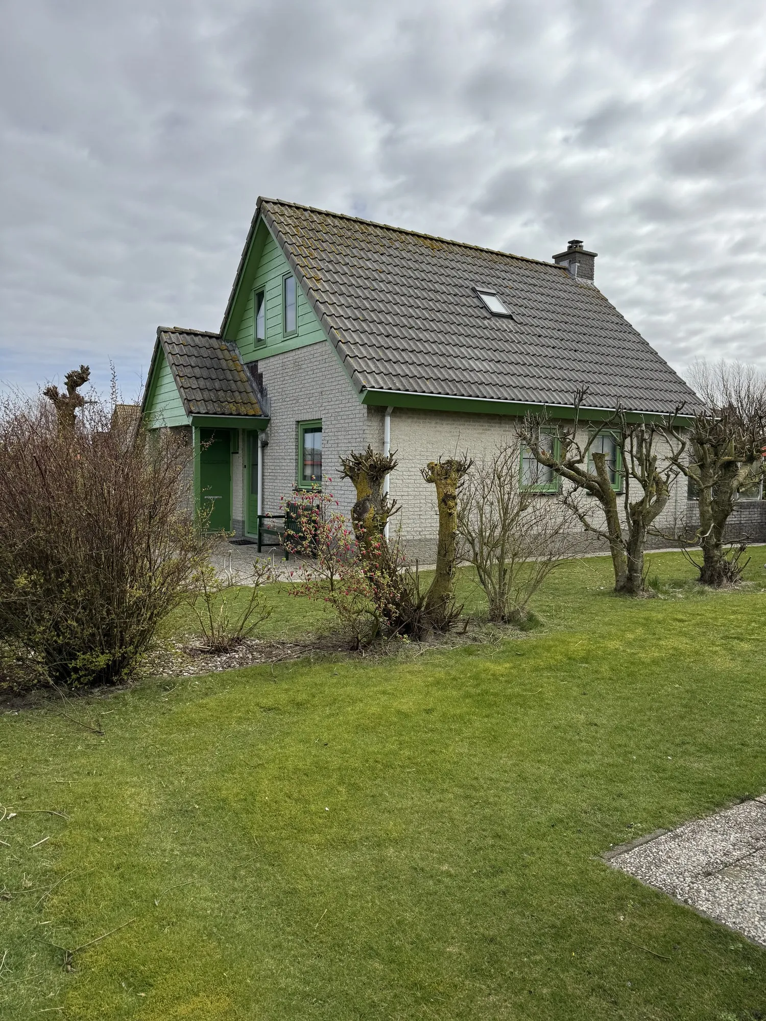 Seitenansicht eines Bungalows mit Vordach und Gartenzugang
