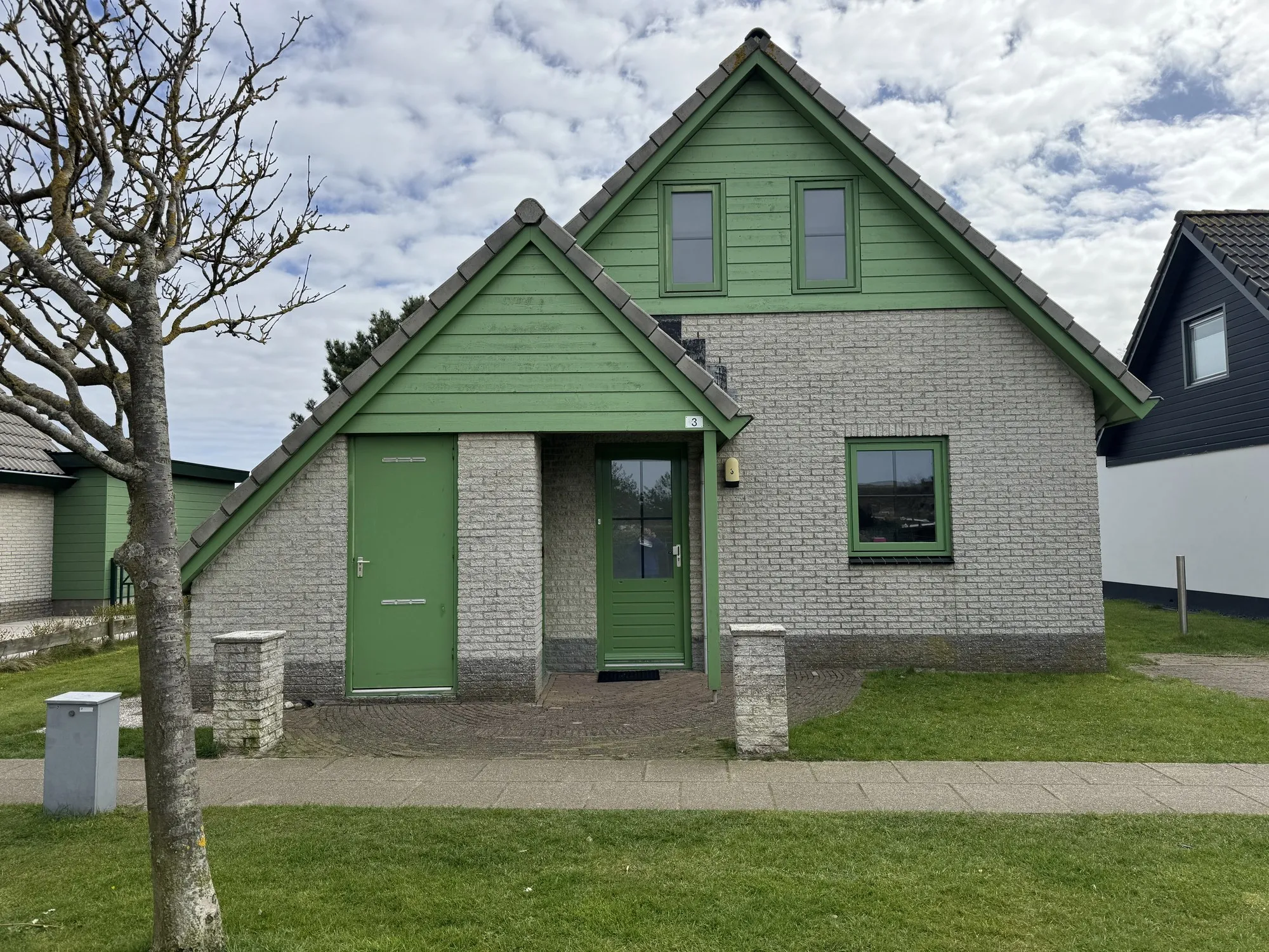 Freistehender Bungalow mit grüner Holzverkleidung im Bungalowpark Strandslag