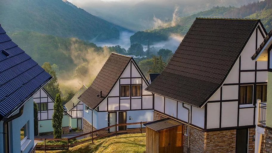 Fachwerk-Ferienhäuser mit Blick ins neblige Tal und Fluss