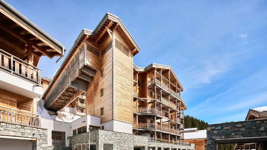 Modernes Holzgebäude mit Steinsockel und mehreren Balkonebenen