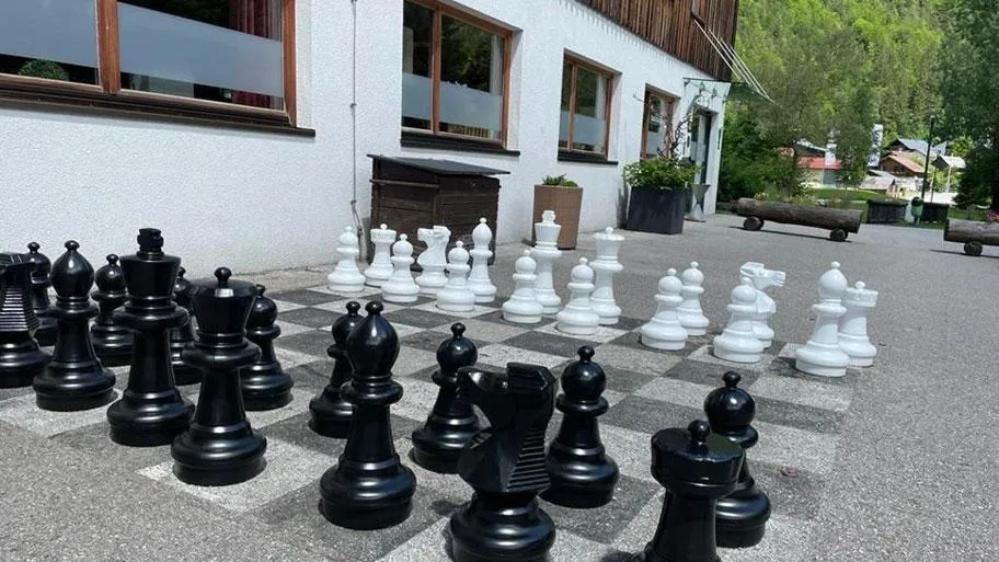 Großes Outdoor-Schachspiel mit schwarzen und weißen Figuren auf Platz