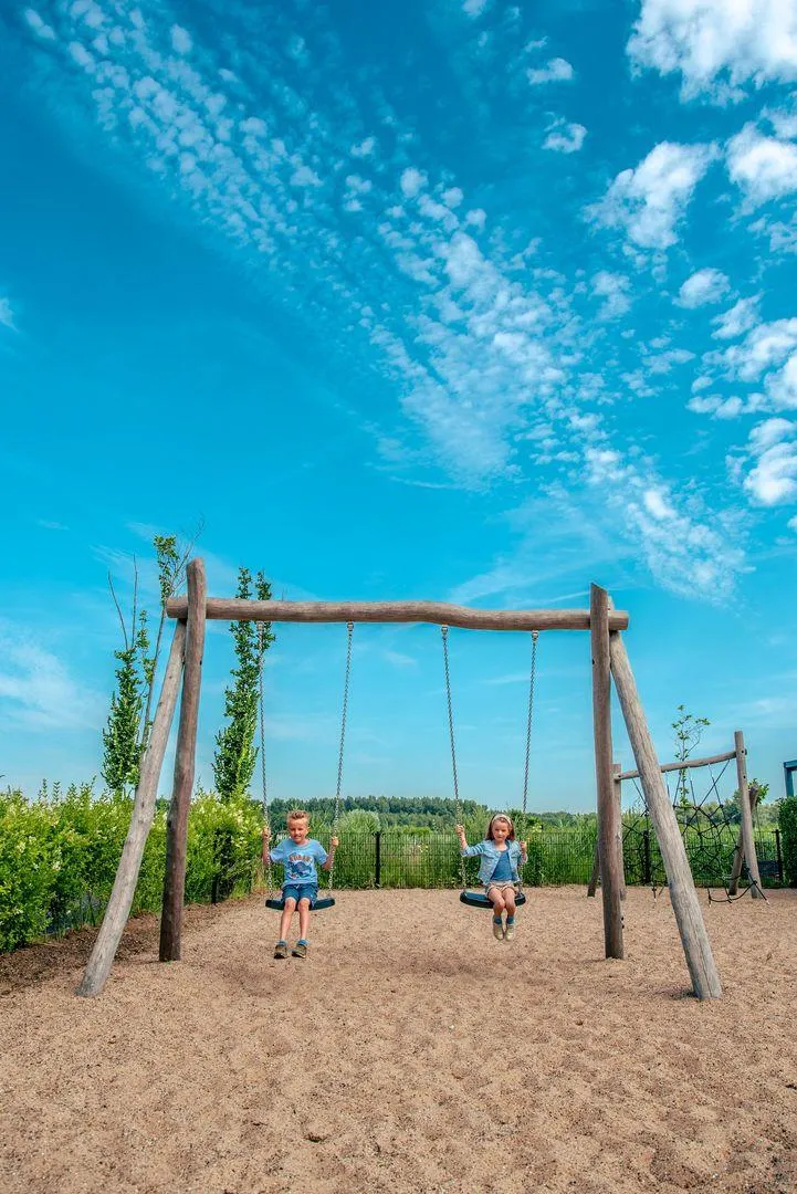 Spielplatz mit Rutsche und Klettergerüsten auf Sandfläche