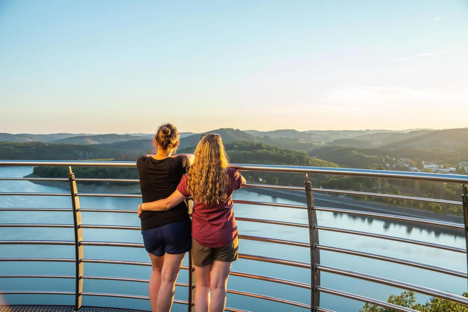Personen auf Aussichtsplattform blicken über Biggesee