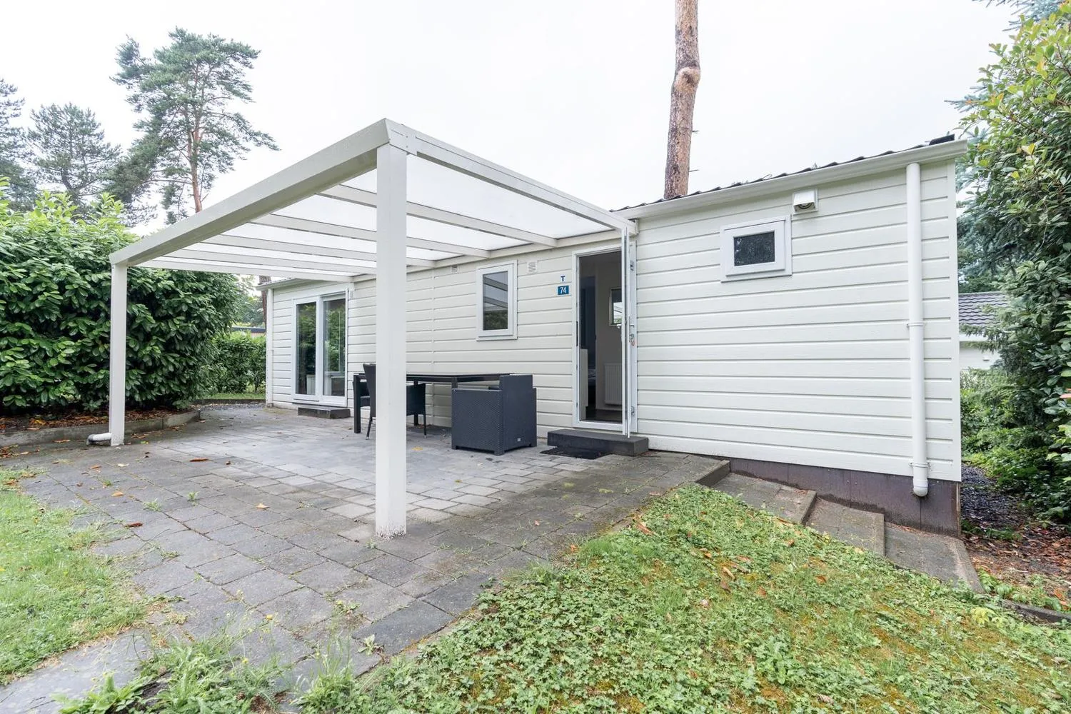 Weiße Ferienunterkunft mit moderner Pergola und Garten