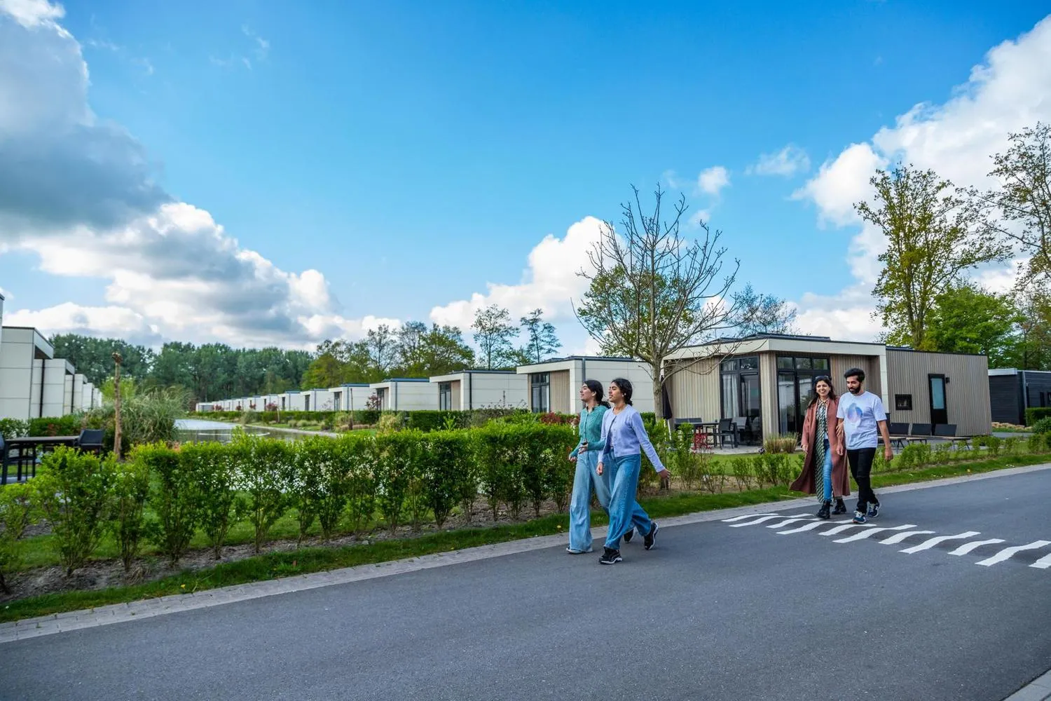 Gehweg zwischen modernen Chalets in grüner Parkumgebung