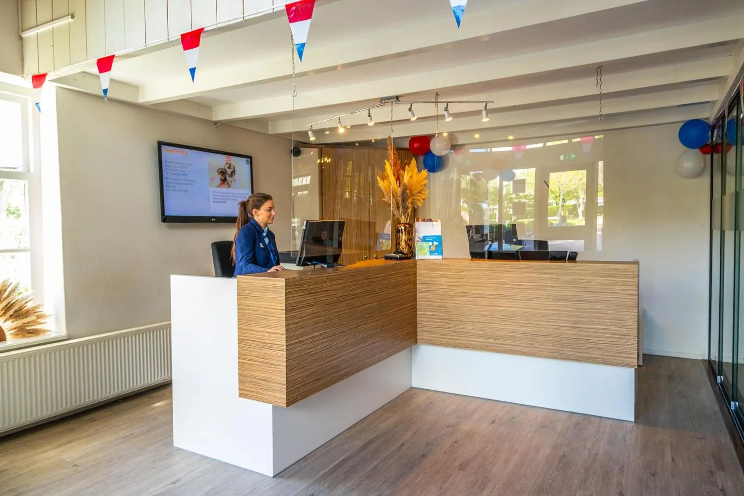 Moderne Rezeptionshalle mit Holztresen und großer Fensterfront