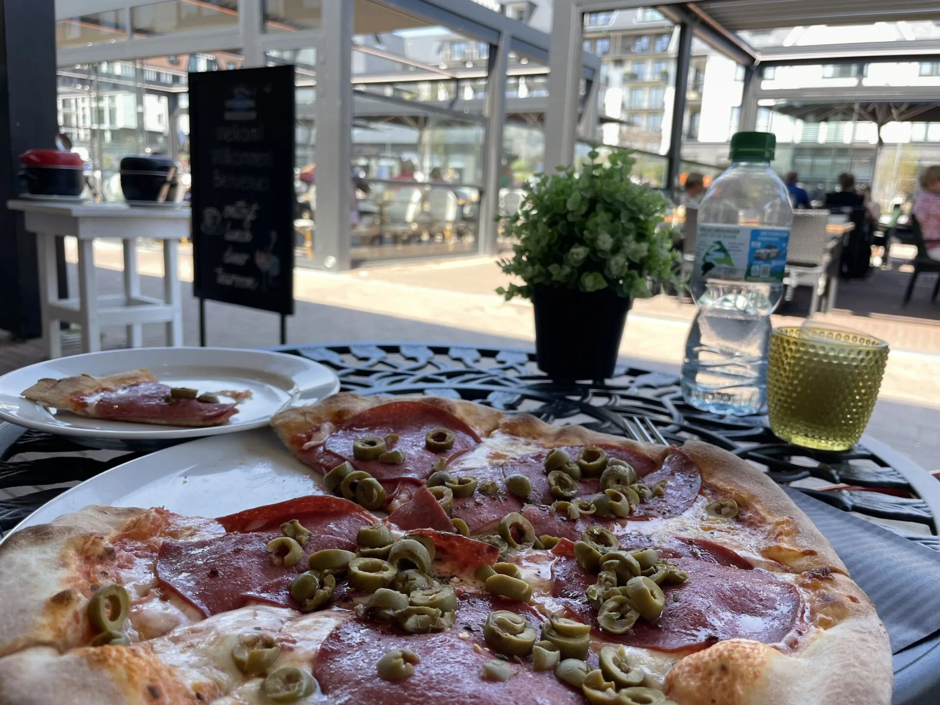 Pizza mit Oliven auf Tisch im Restaurant mit Fensterblick