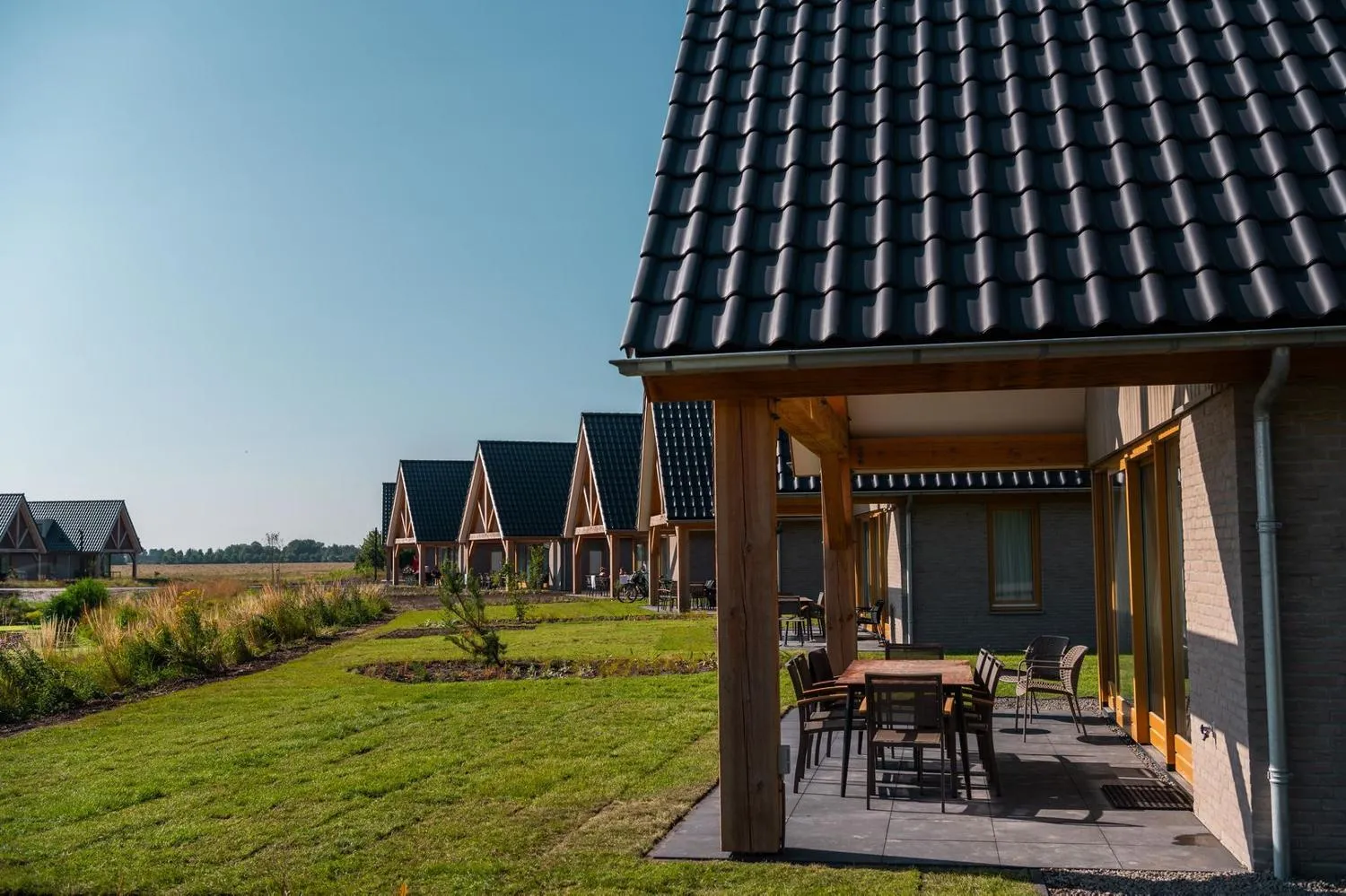 Veranda mit Sitzbereich und Reihe moderner Ferienhäuser