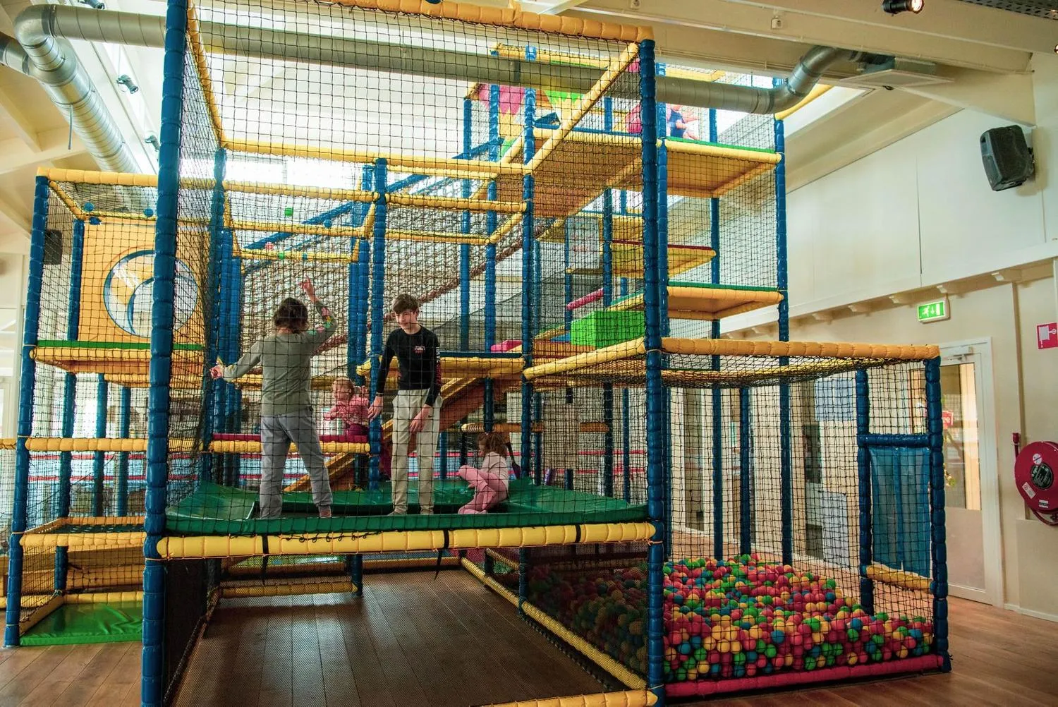 Indoor-Kletteranlage mit Trampolinen und bunten Gummibällen im Ferienpark
