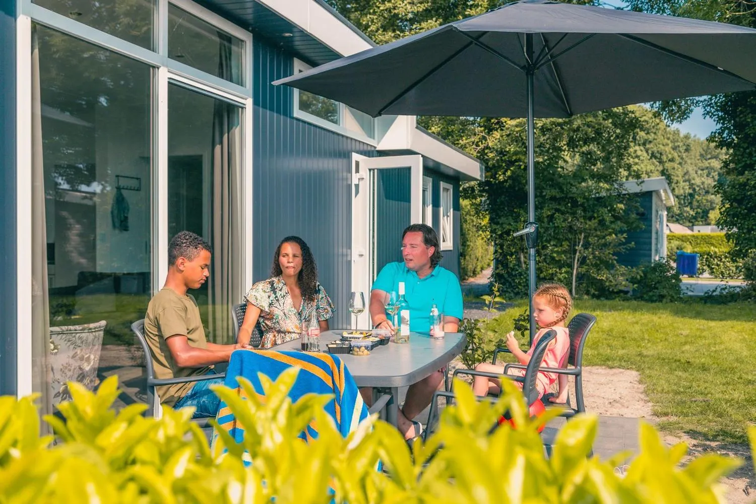 Gäste beim Mittagessen auf der Terrasse vor ihrem Häuschen