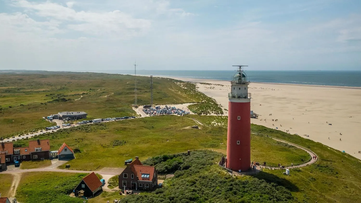 Leuchtturm mit Landhäusern, gepflastertem Pfad zur grünen Düne
