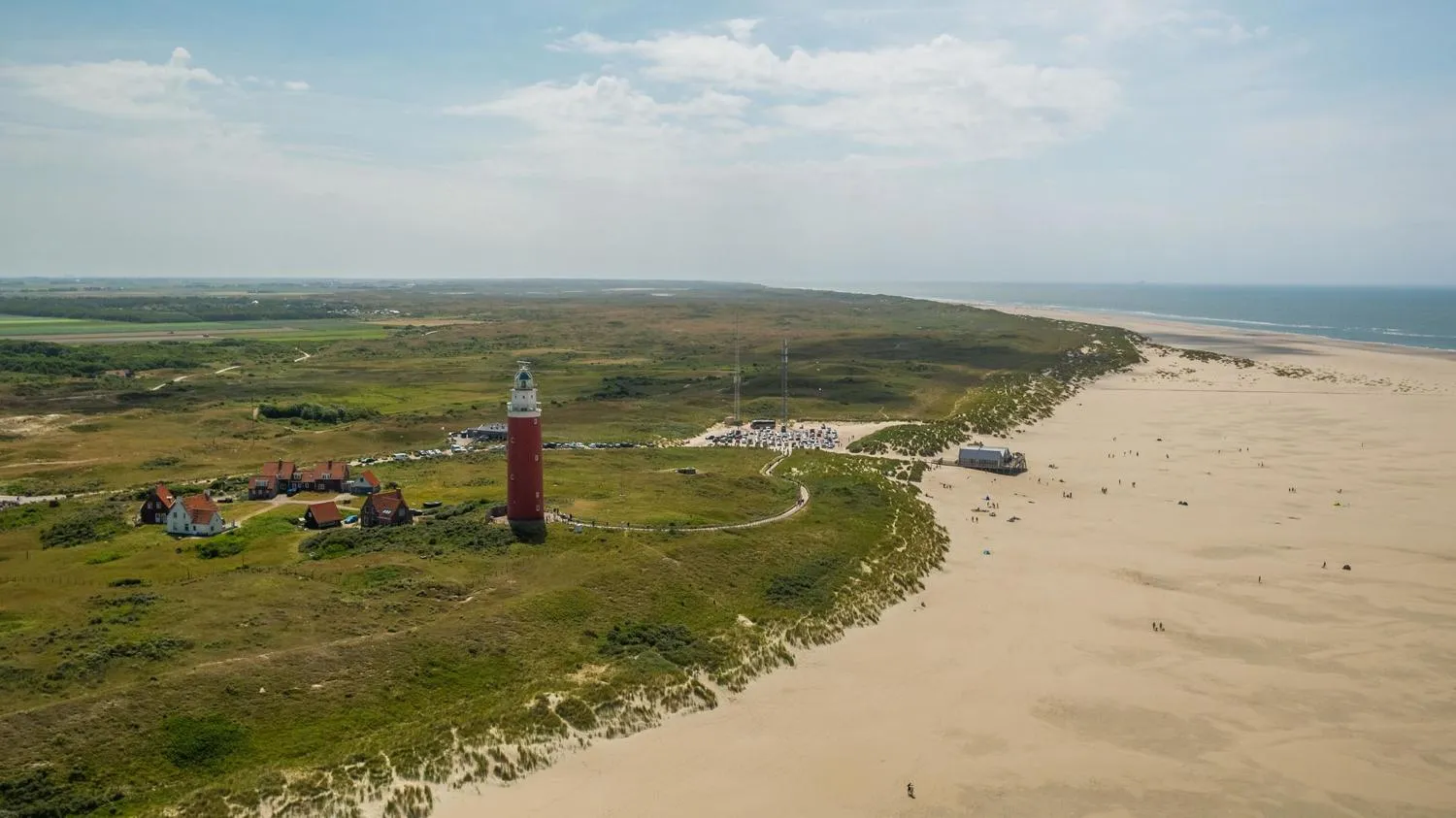 Kinder spielen am Strand mit bunten Strandzelten und Sonnenschirmen