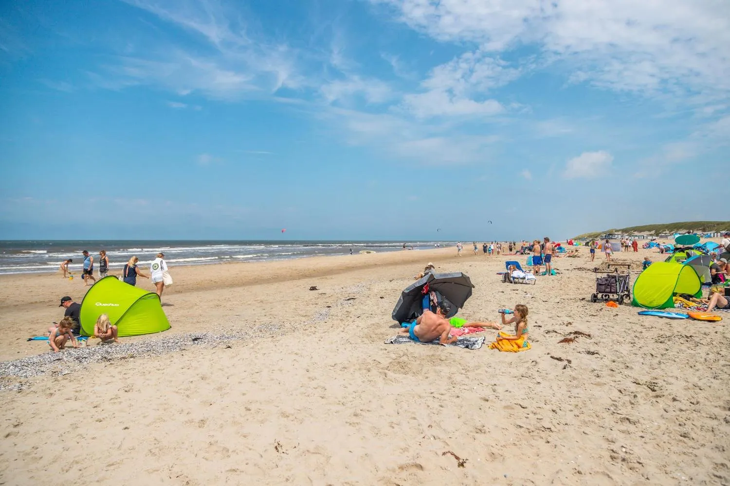 Zwei Mädchen spielen im Sand am Nordseestrand bei Sonnenschein