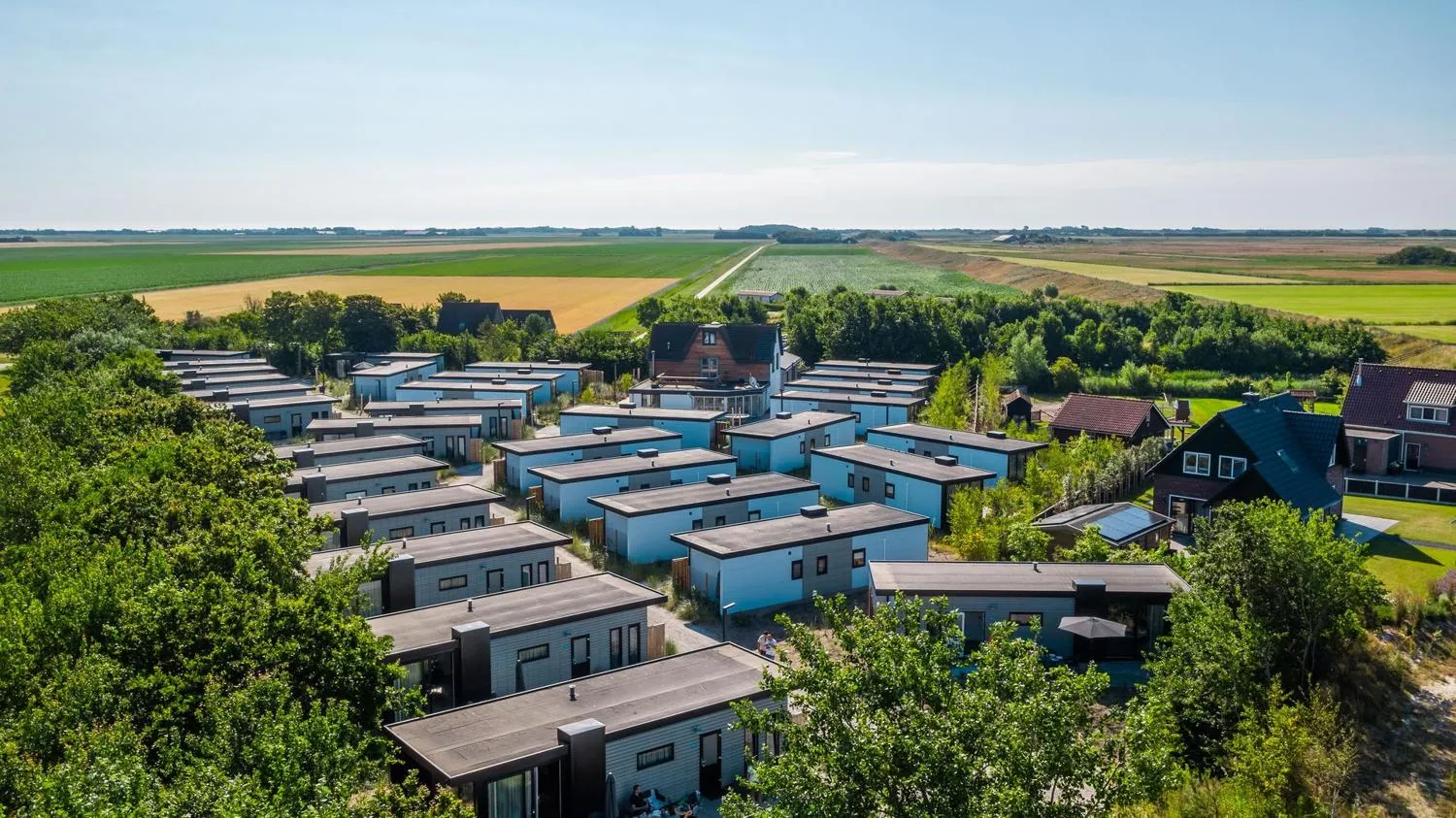 Ferienpark mit modernen Häusern eingebettet in breite Feldlandschaft