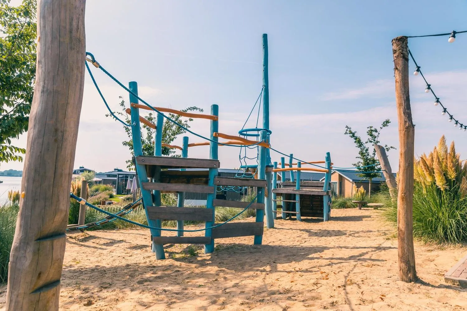 Moderner Kletterplatz aus Holz und Seilen am Sandstrand des Parks