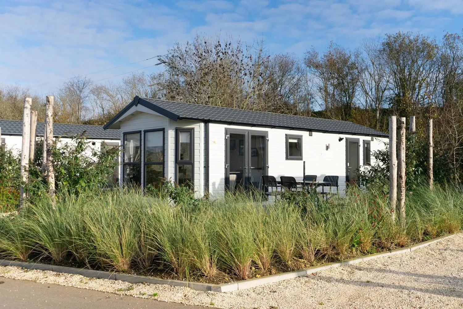 Modernes weißes Ferienhaus mit großzügigen Fenstern und Ufergarten