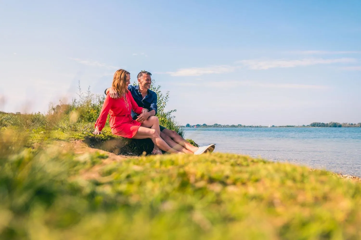 Paar entspannt am Ufer des Sees mit Blick auf das Wasser