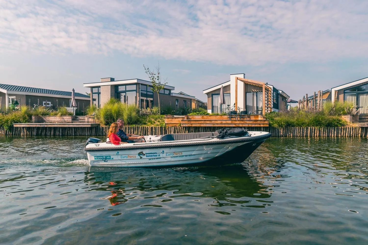 EuroParcs-Boot vor modernen Wasserfrontchalets und Holzstegen