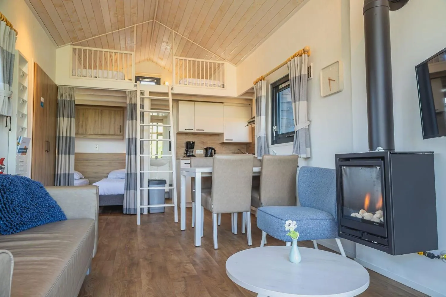 Offenes Wohnzimmer mit Kamin, Sofa, Esstisch und Küche
