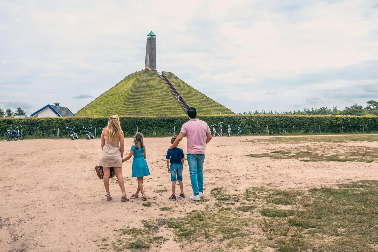 Familie auf Sandhügel mit markantem Sendeturm