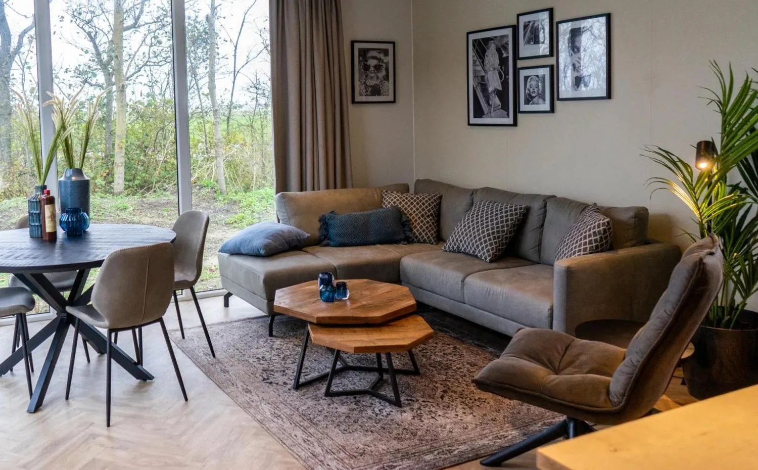 Wohnzimmer mit orangefarbener Couch, blauen Sesseln, Waldblick