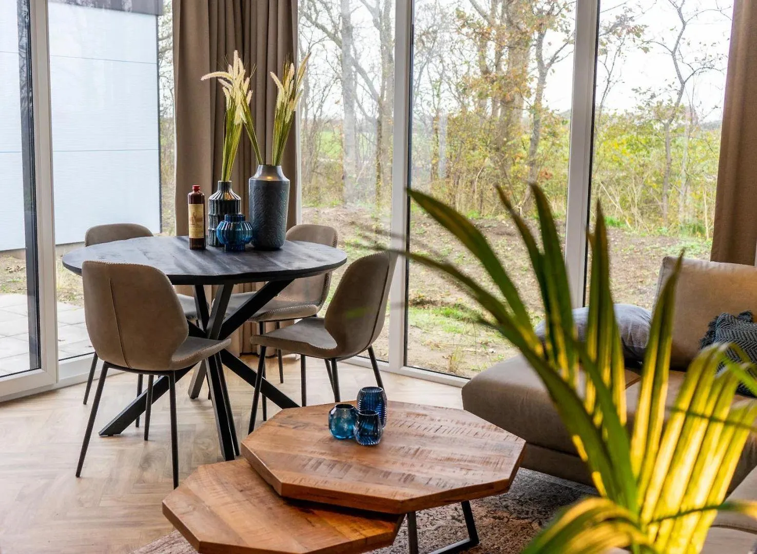 Esszimmer mit Holztisch, blauen Stühlen und Blumenvase