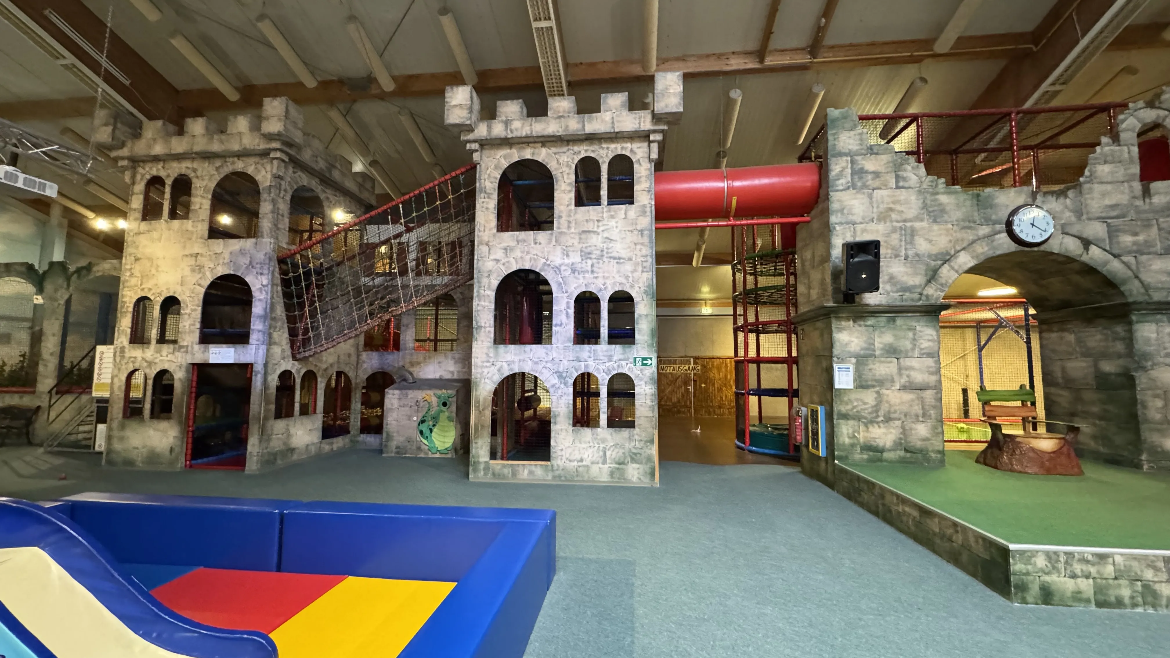 Spiellandschaft der Indoor-Ritterburg im Landal Sonnenberg mit Kletternetzen hinter den Burgfenstern