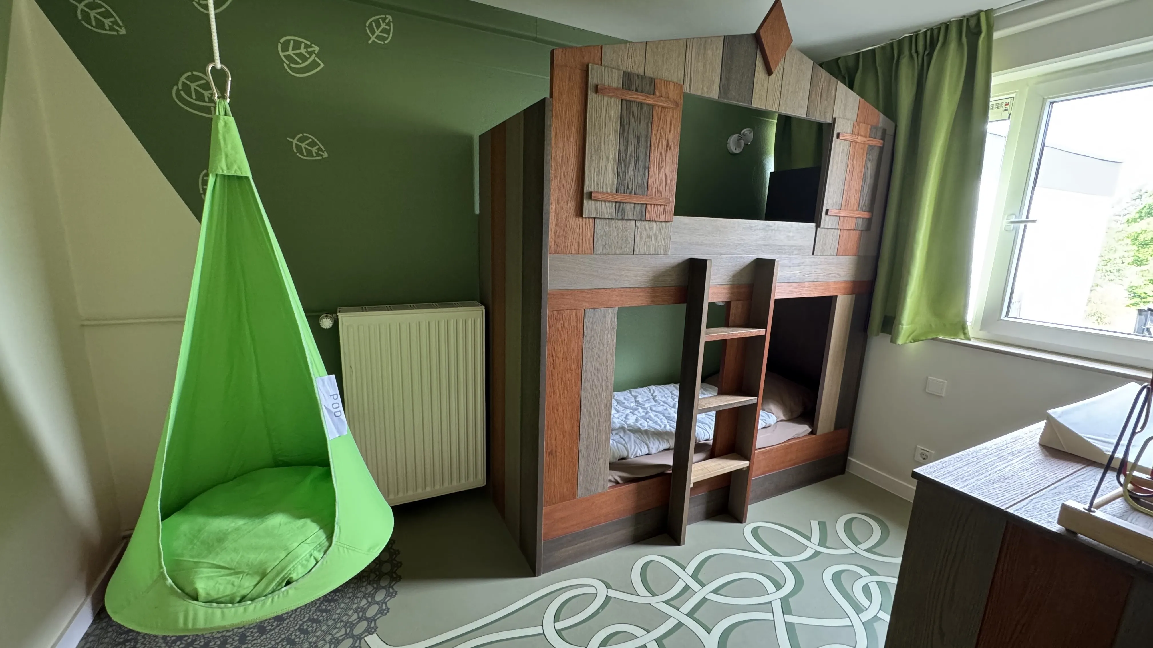 Grüner Hängesessel neben dem Hochbett im Kinderzimmer des Landal Sonnenberg